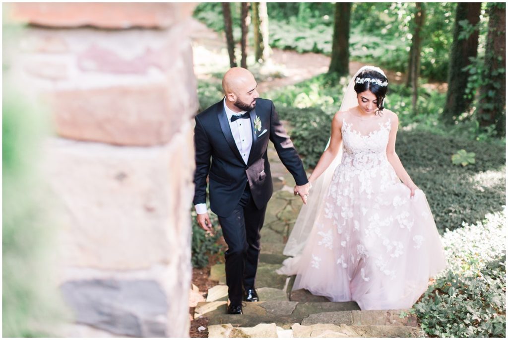 A bride and groom holding hands walking up steps on their wedding day at the Club at Hillbrook