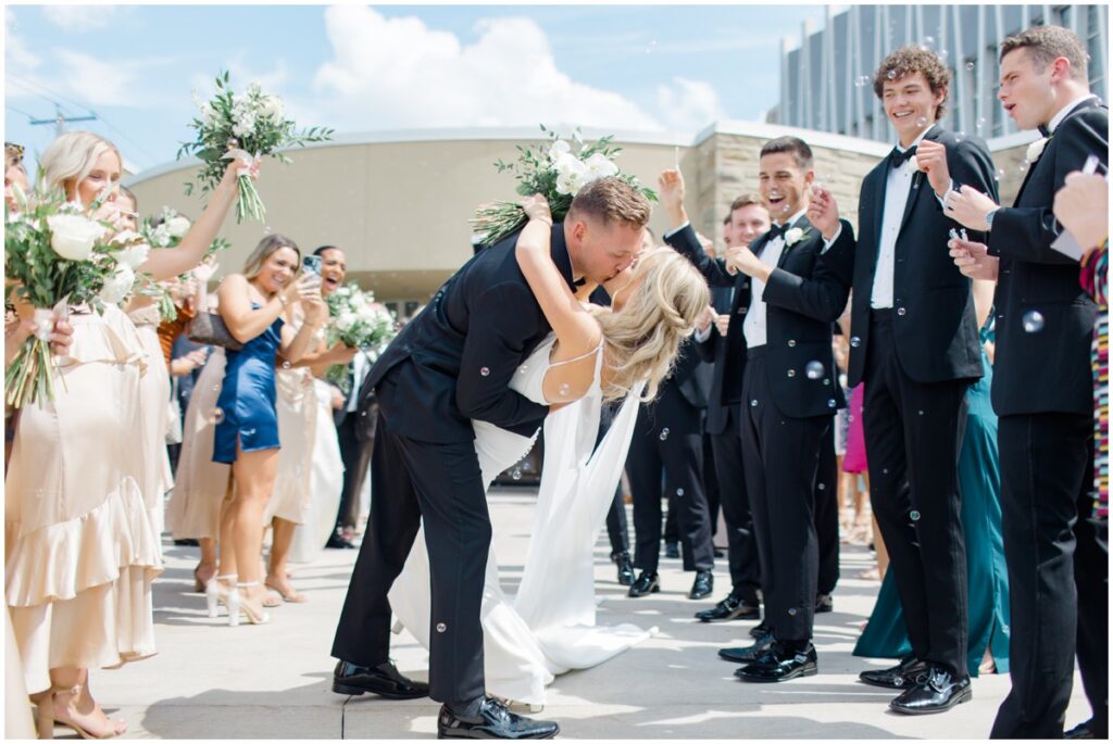 bride and groom kissing in front of a church