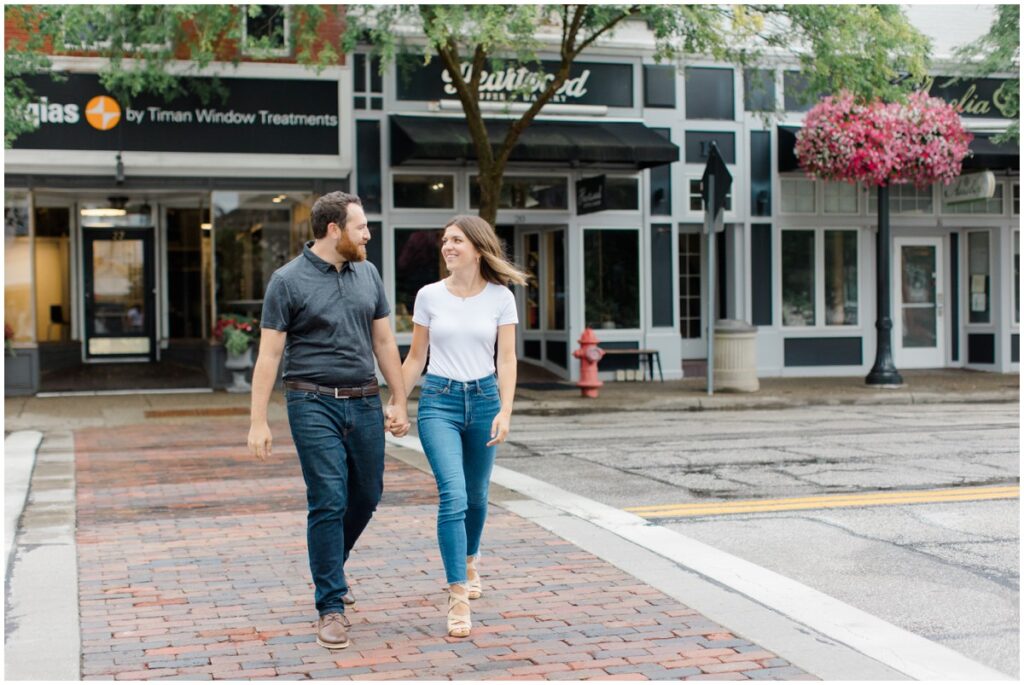 a couple walking across the street holding hands in downtown chagrin falls