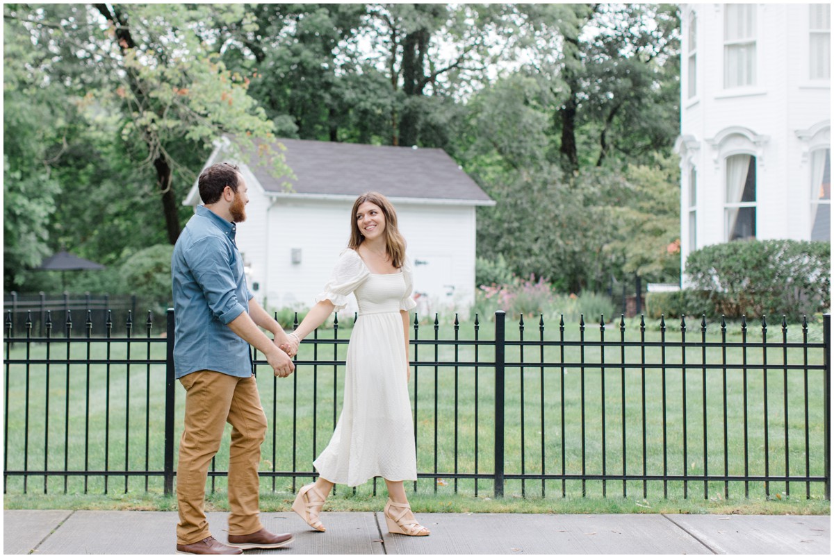 An engaged couple walking on the sidewalk in Chagrin Falls