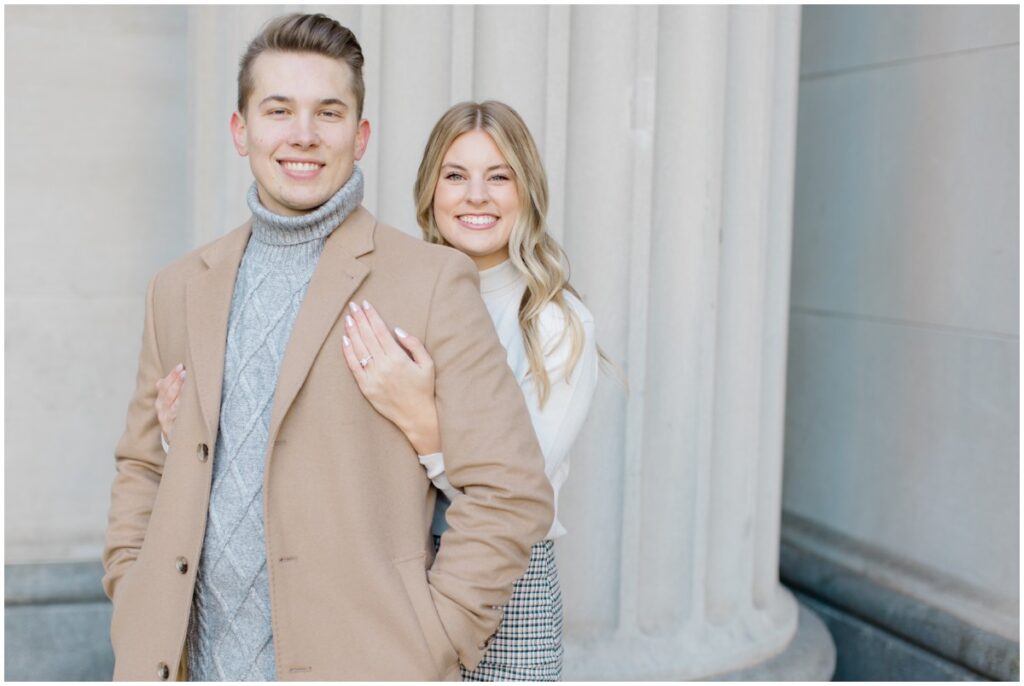 An engaged couple posing outside Terminal Tower in Cleveland Ohio for their engagement session