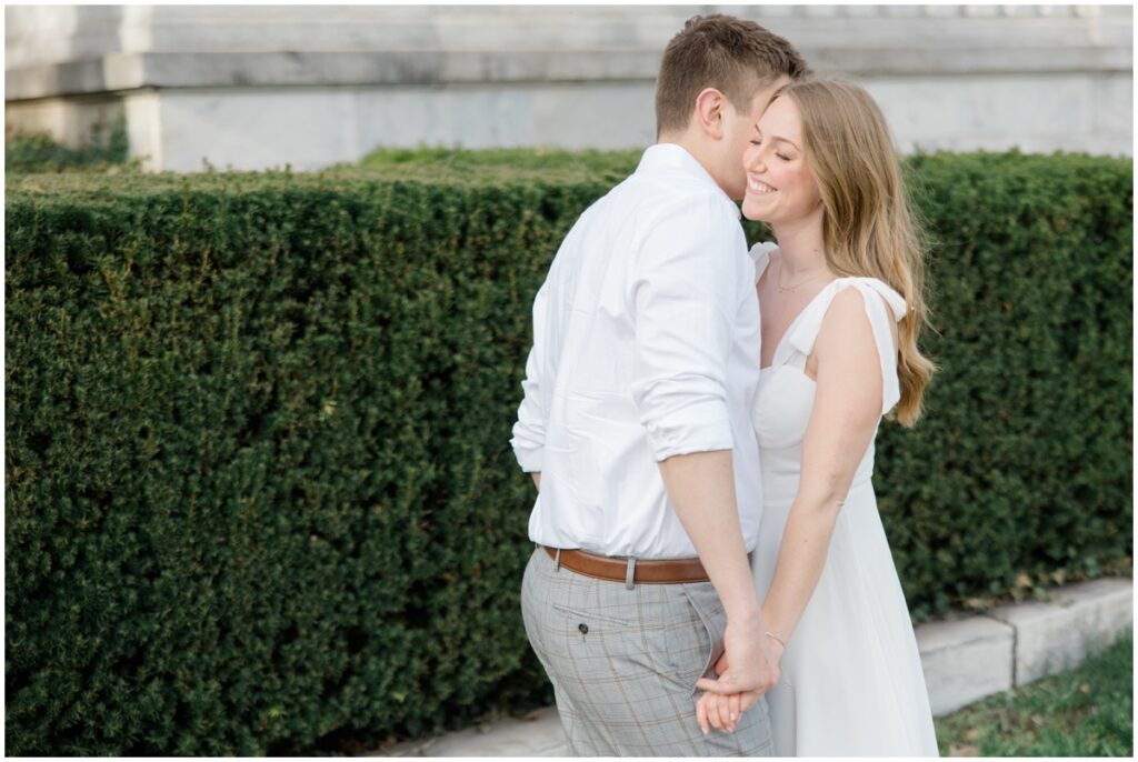 A couple holding hands facing each other smiling during their engagement session at the cleveland museum of art