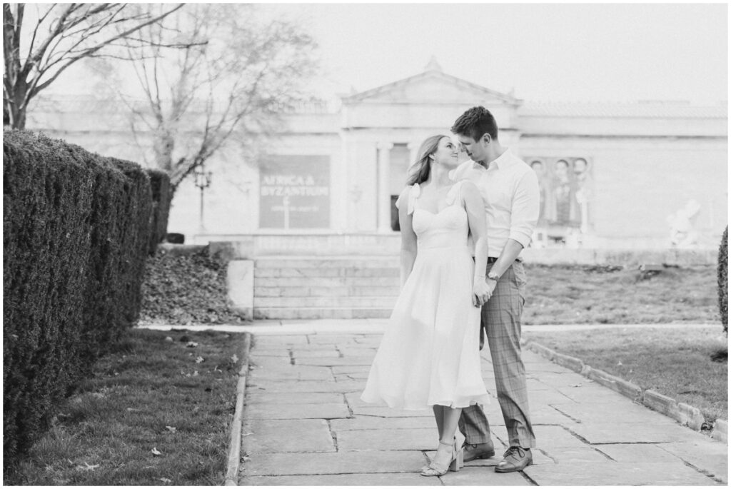 A couple holding hands looking at each other in front the the Cleveland museum of art 