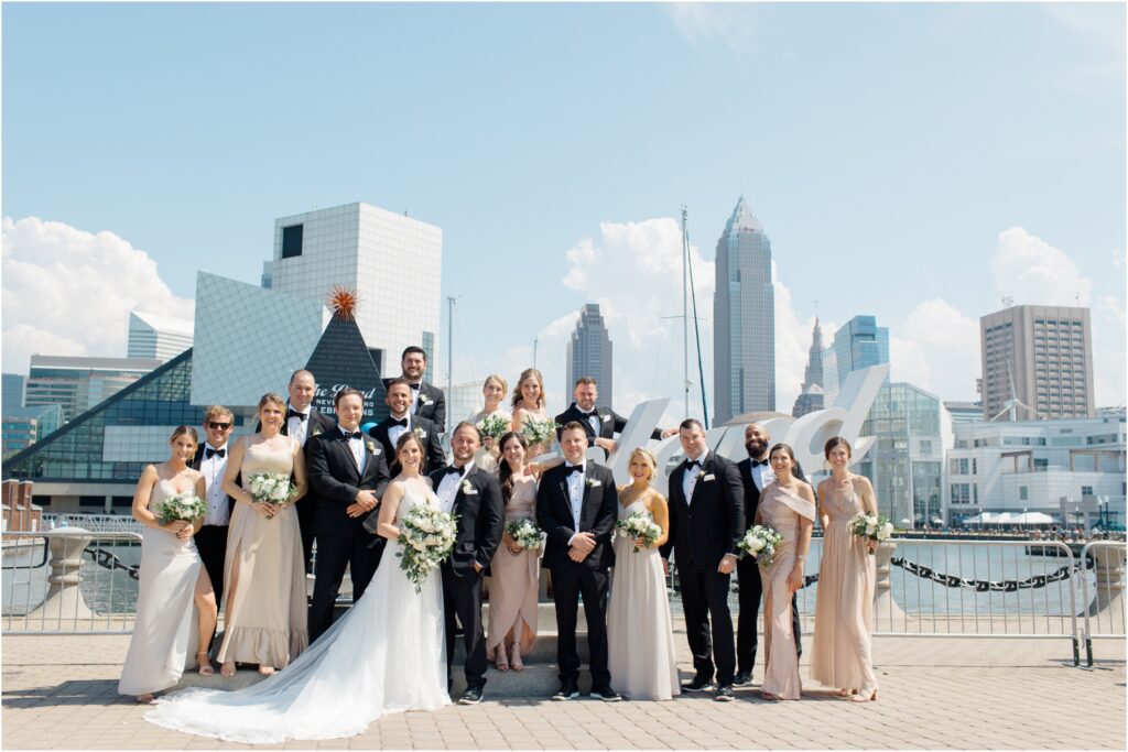 A wedding party posing in front of the cleveland script sign for their wedding photos.