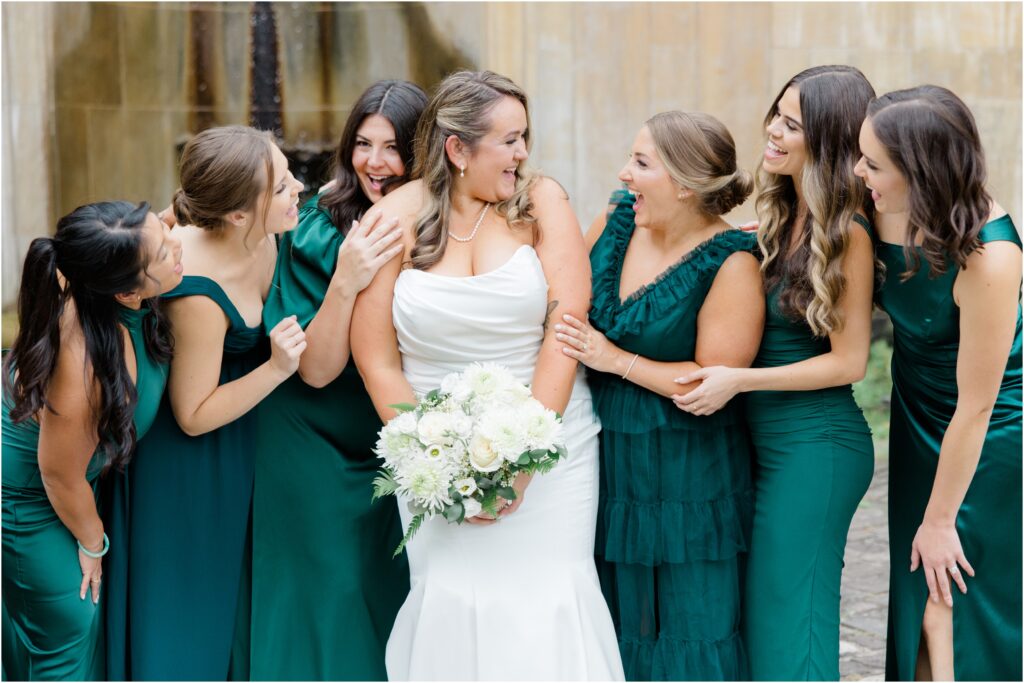 A bride laughing with her bridesmaids at the Italian Cultural Gardens in Cleveland Ohio.