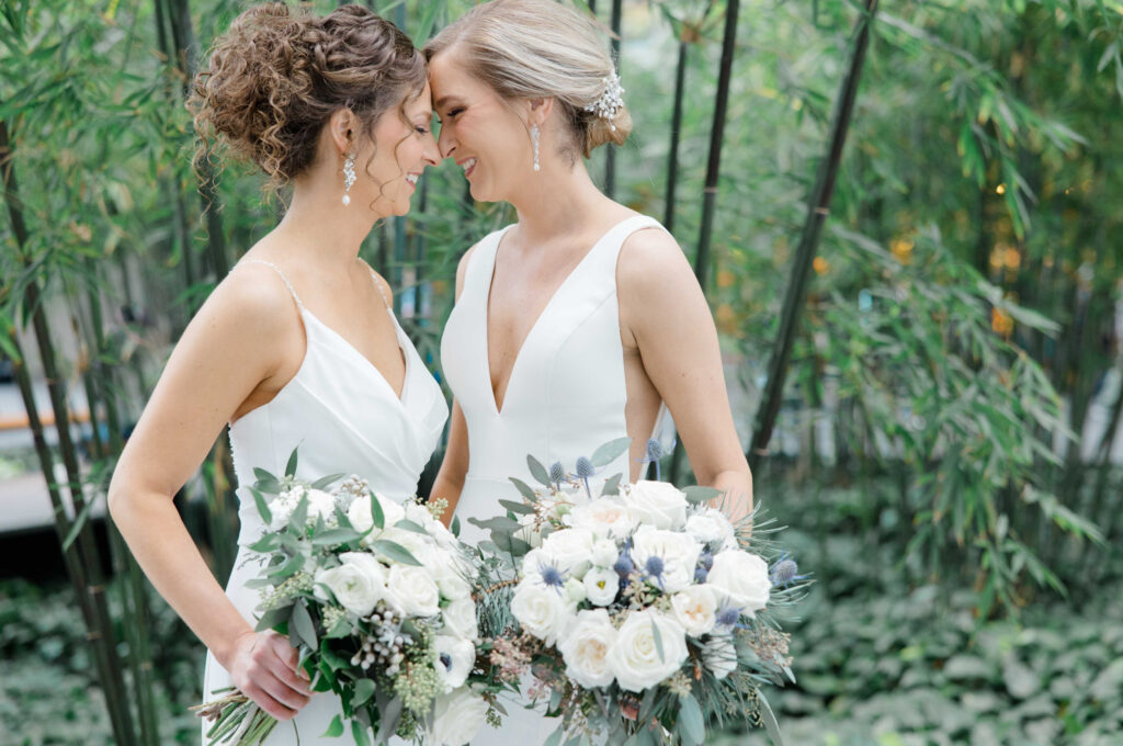 Two brides embracing each other at the Cleveland Museum of Art on their wedding day