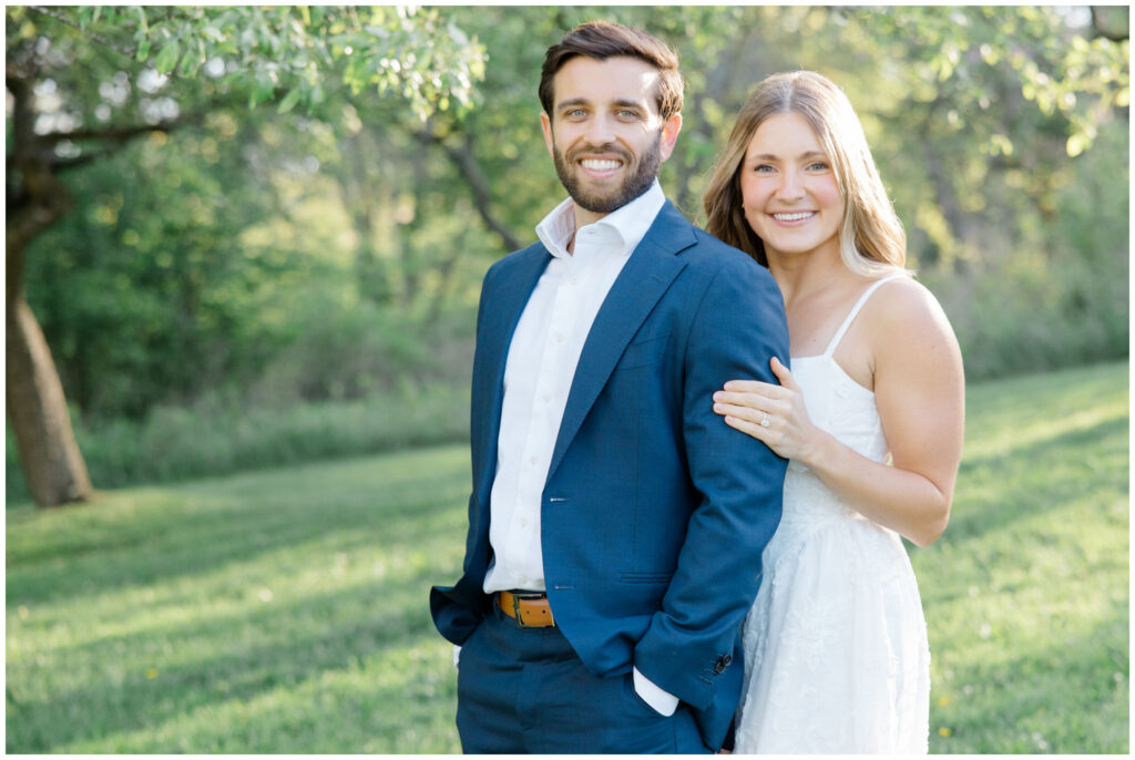 A girl embracing her fiancé as they pose for their engagement session photos at Seiberling nature realm in Akron Ohio