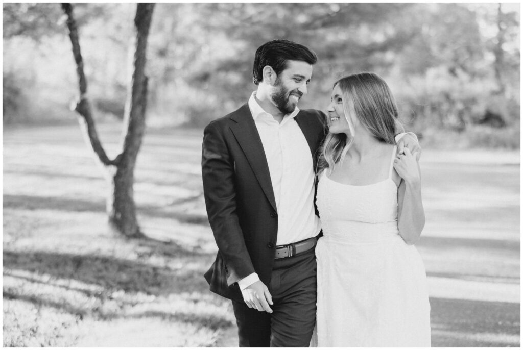 A couple walking down a path smiling at each other for either engagement session in Akron Ohio.