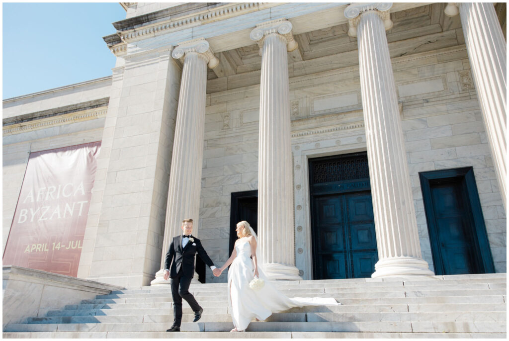 A couple walking down steps for their wedding photos at the Cleveland Museum of Art
